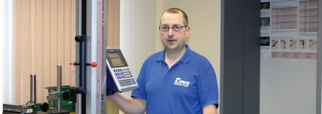 Ein mittelalter Mann steht an einer Messmaschine