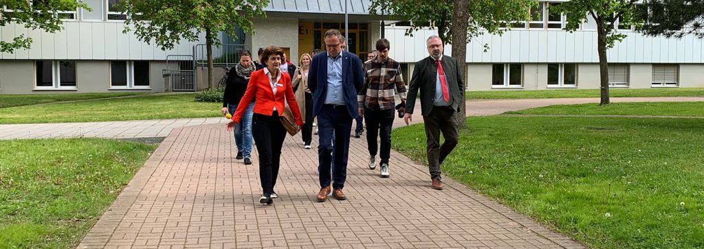 Eine Personengruppe läuft durch die parkähnliche Anlage im BFW Thüringen