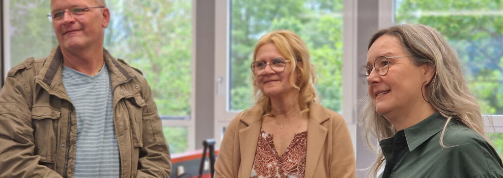 drei Personen stehen in einem Umschulungsraum im BFW Thüringen