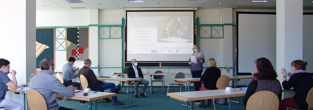 eine Frau hält einen Vortrag in einem großen Raum