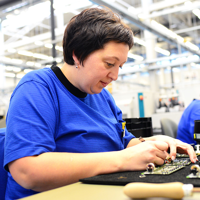 Eine Frau arbeitet an einer Platine