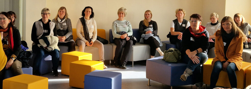 Eine Gruppe Frauen sitzt auf bunten Hockern