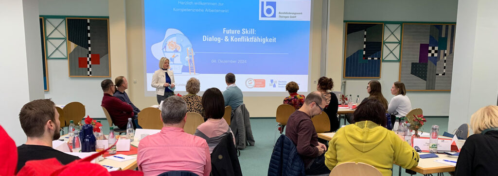 Eine Frau begrüßt die Gäste zur Veranstaltung im BFW Thüringen