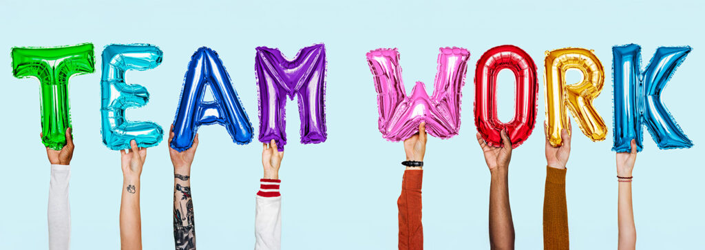 Hände halten Luftballon-Buchstarben "TEAM WORK"