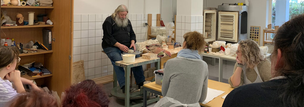 Töpfer zeigt den Umschülerinnen Ton