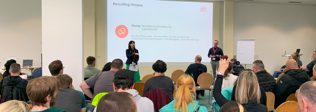 Zwei Personen halten einen Vortrag zum Recruitingprozess